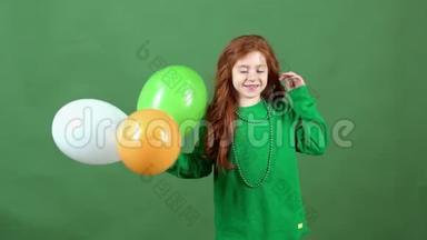 女孩红发庆祝圣帕特里克节`<strong>绿墙</strong>背景站着气球